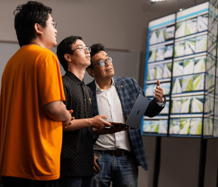faculty and students looking at screens in the distance