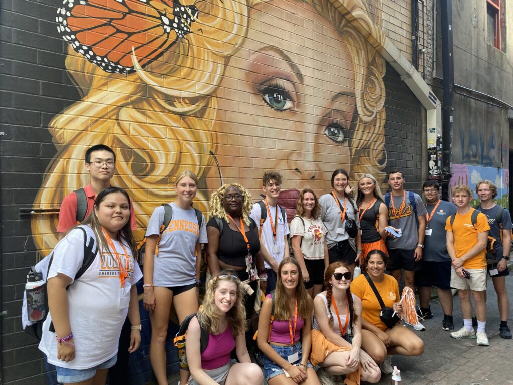 past AGS cohort group photo by the Dolly Parton mural in Market Square