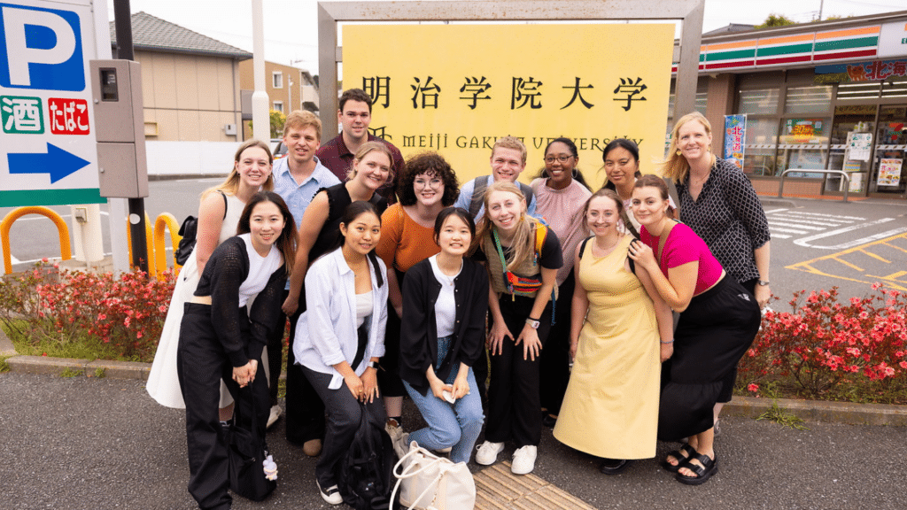 Group of 14 students and a professor in the streets of Japan.