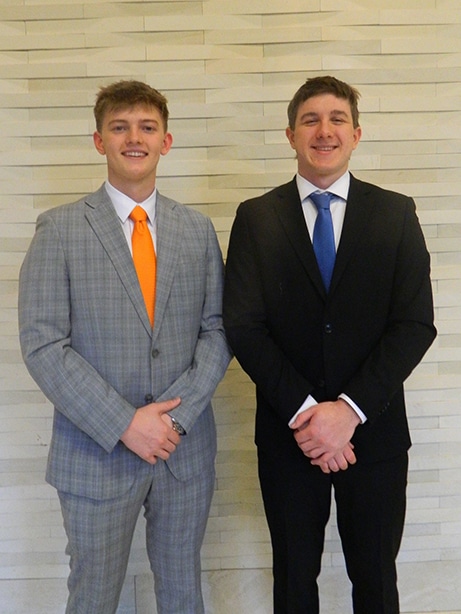 Nicholas Heisig and Nathan Surdej pose wearing suits.